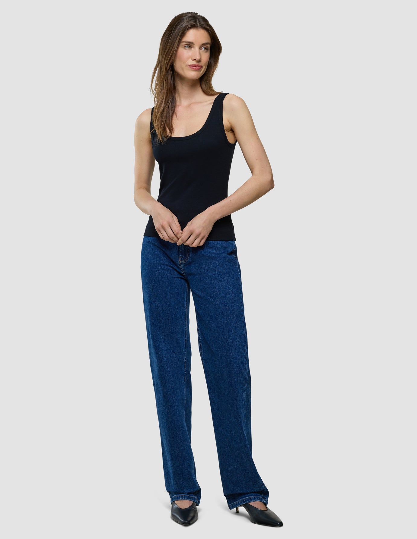 Rib Top i Black, helfigur med sort top og blå jeans.